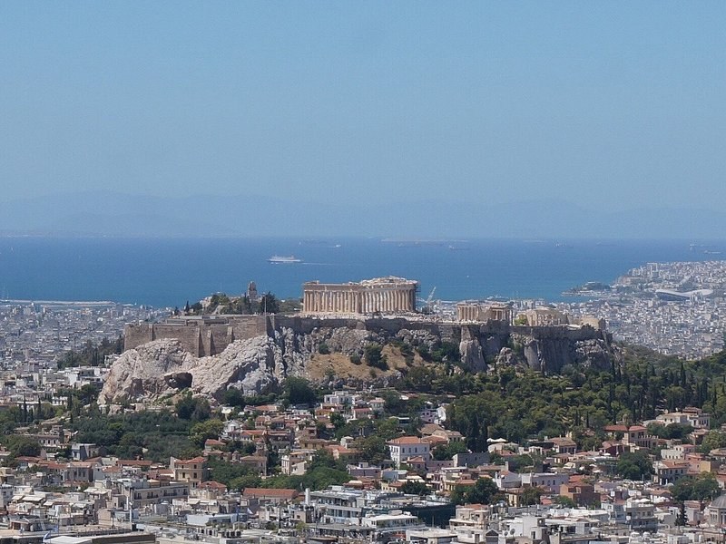 The Acropolis in the middle of Athens, the city running out to the sea behind it