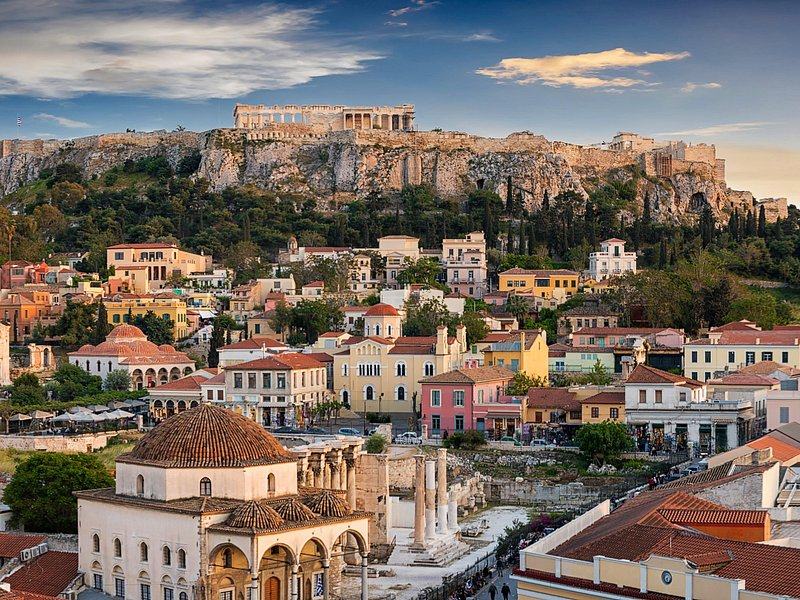 The Acropolis rock rising over the tiled roofs and a domed mosque in the old town below