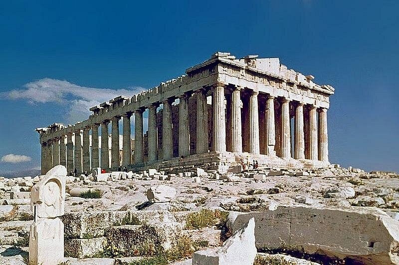 The Parthenon from its north-west corner, marble blocks scattered on the rock in front